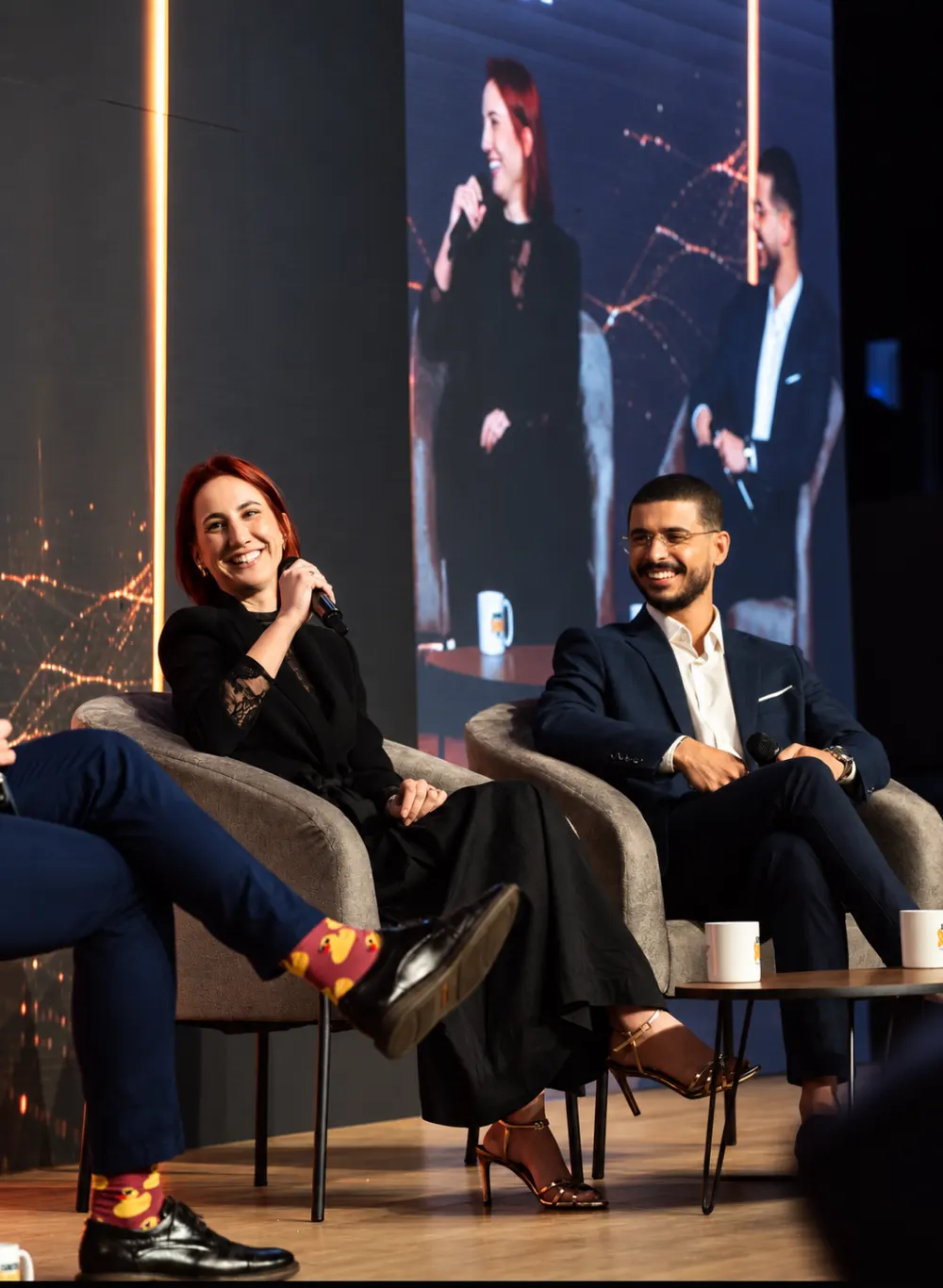 May Portugal e Bruno Berrios sentados no palco durante apresentação