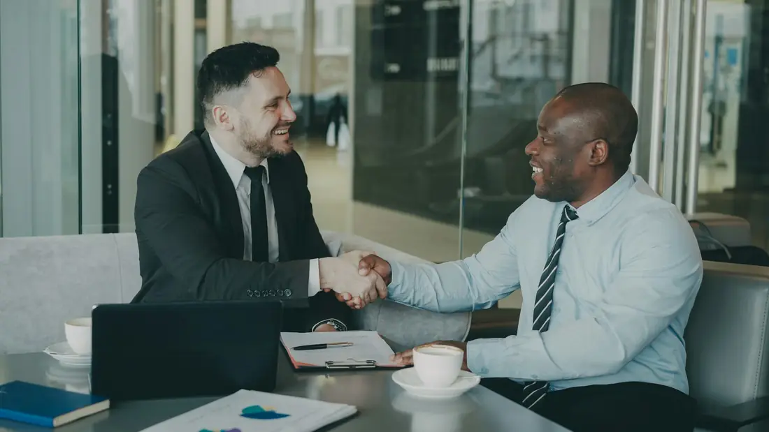 Dois empresários fechando negócio com um aperto de mão